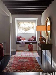 A hallway with a beautifully decorated rug and a stylish lamp.