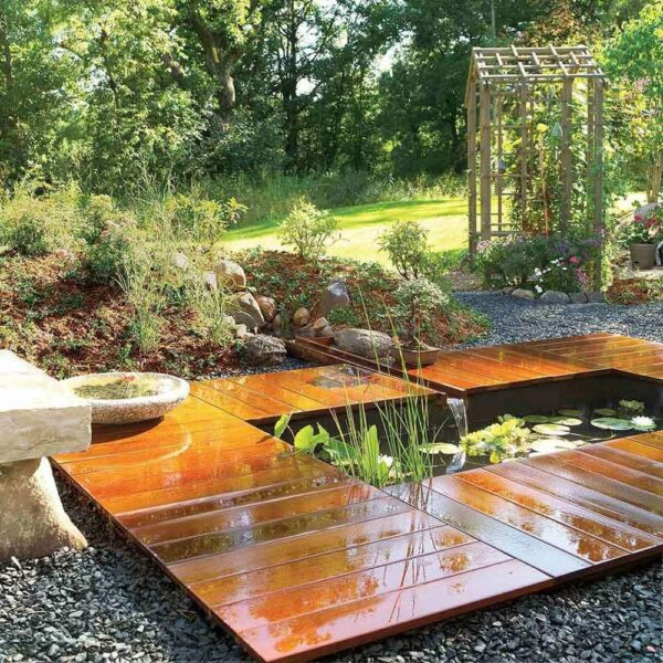 A wooden deck with a pond in the middle, enhanced by Six Facelifts.