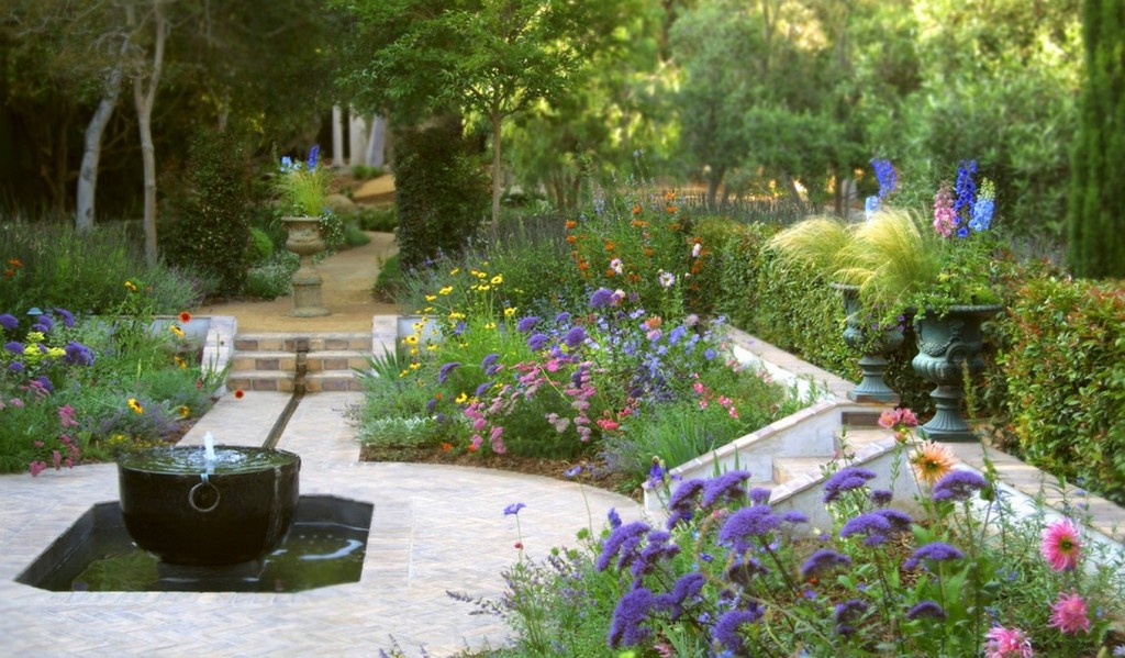 A classic garden with a fountain and colorful flowers at a manor house.
