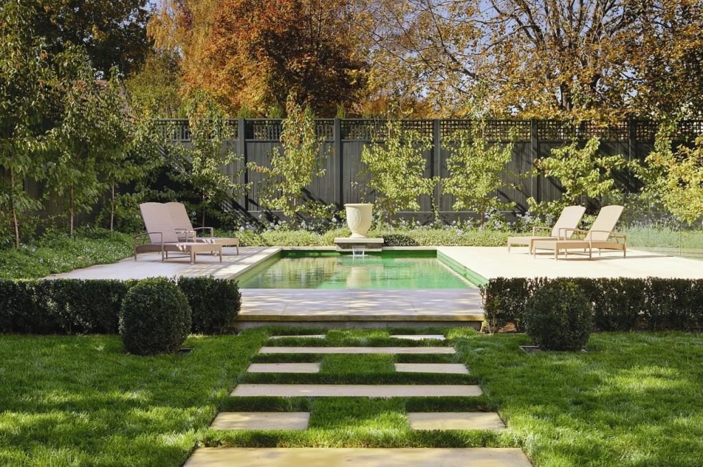 A classic backyard with a pool and lawn chairs.
