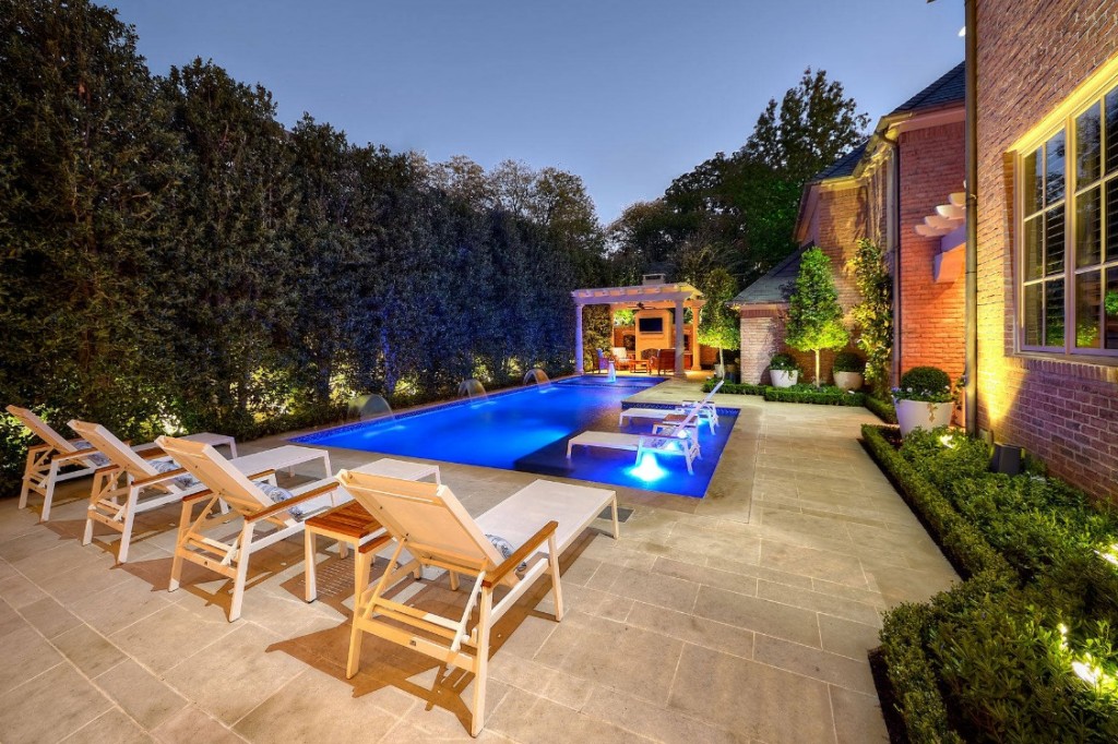 A classic backyard with a swimming pool and lounge chairs.