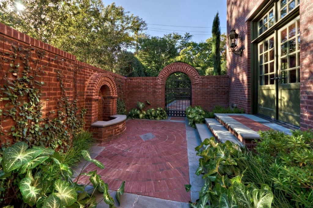 A classic courtyard with a brick wall and plants.