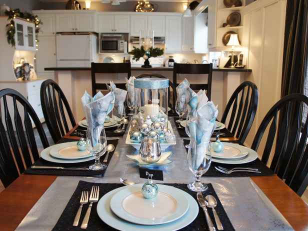 A festive Christmas tablescape with blue and white plates and silverware.
