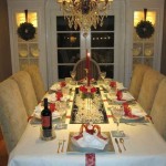 A festive dining room table is set for a Christmas dinner with stunning tablescapes.