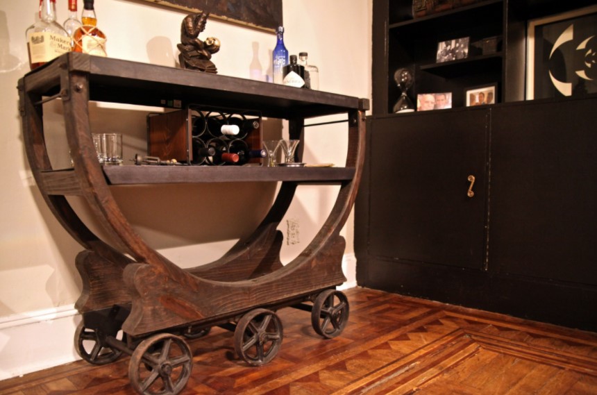 A wooden conversation piece on wheels in a room.