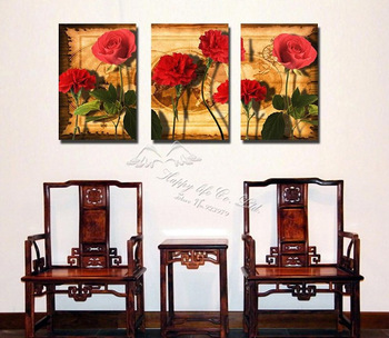 Travel photo of three red roses on a wooden table.