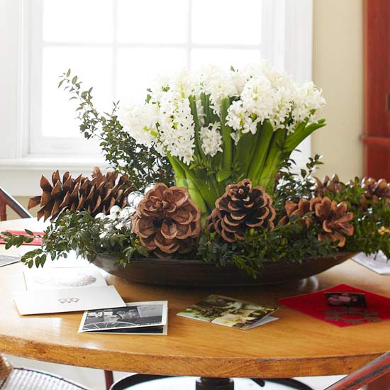 A wooden table with winter floral arrangements.