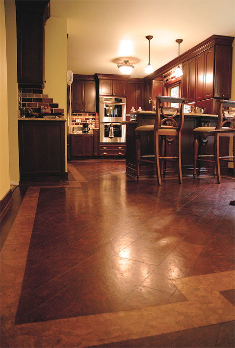 A kitchen with alternative hard wood floors and a bar area.
