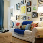 Create a collage in a living room with pictures on the wall.
