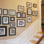 A black and white collage of framed pictures displayed on a staircase.