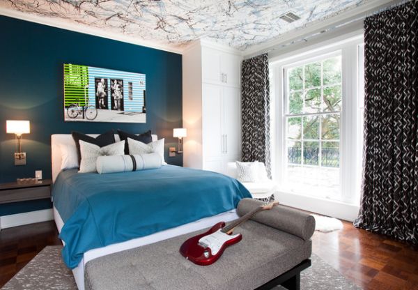 A blue and white bedroom with a guitar on the bed, featuring unique wall design.