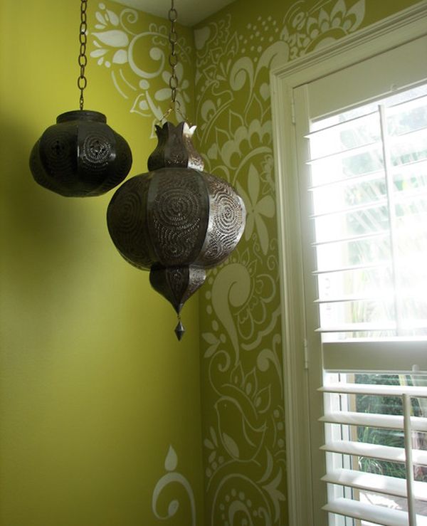 A room with a green wall design and two hanging lanterns.