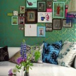 A living room with framed pictures and green wallpaper suitable to create a collage.