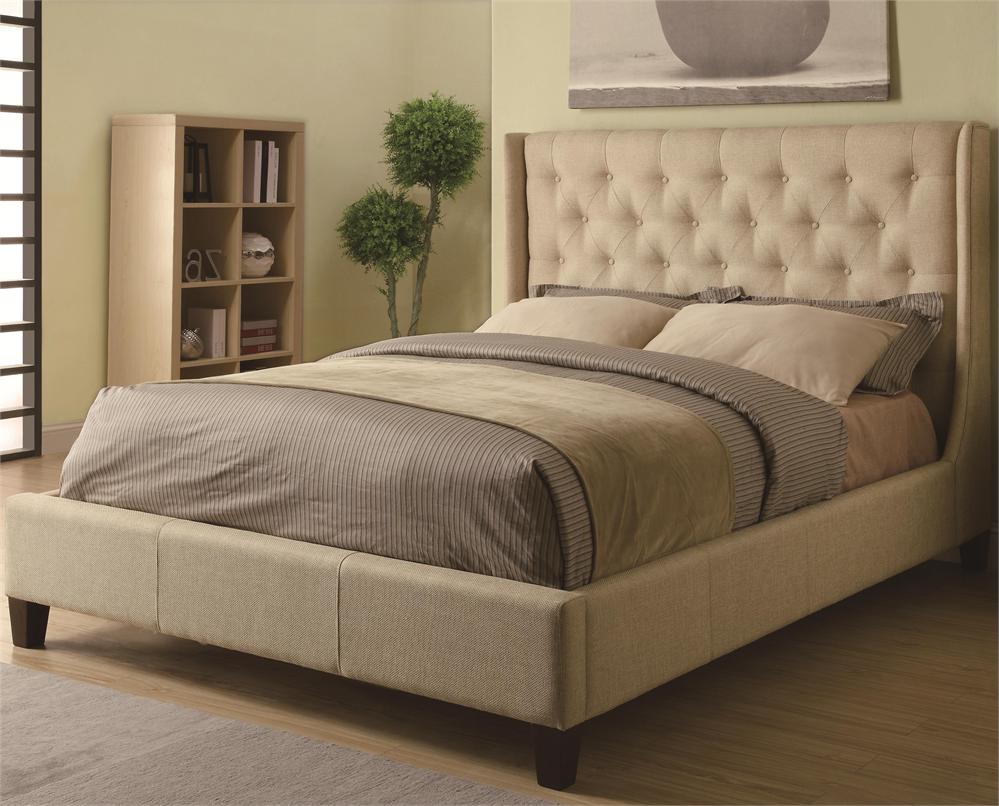A beige upholstered bed featuring a headboard.
