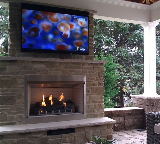 Outdoor fireplace with a TV.
