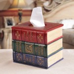 A stack of books hiding tissue boxes on top of a table.
