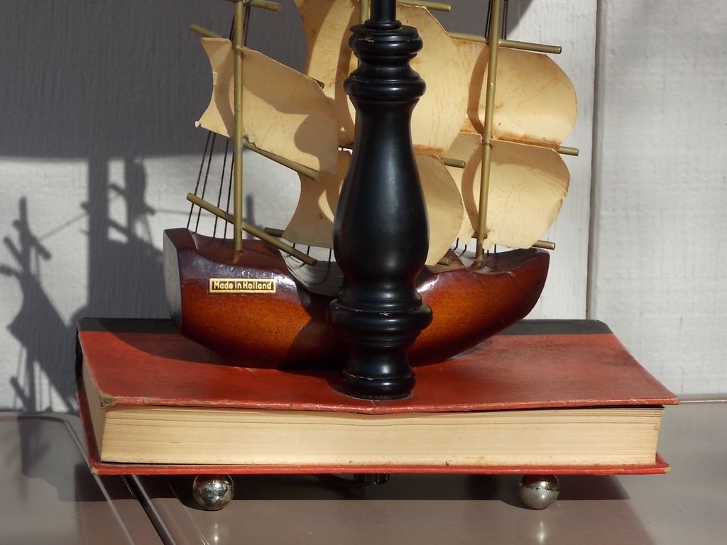 A lamp with a ship-shaped wooden bookend.