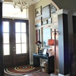 The entryway of a home has a wooden floor and framed pictures.