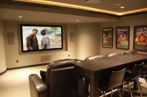 A movie room with a tv on the wall.