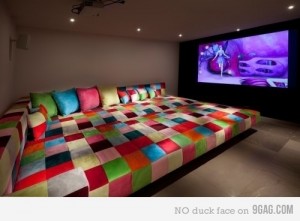 A movie room with a colorful couch and TV.