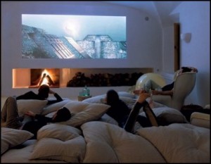 A group of people lounging on pillows in a movie room.