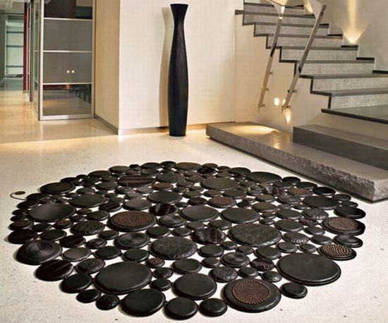 A circular rug made of black stones in a living room.