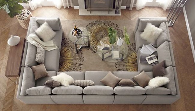 An aerial view of a living room with a large sectional couch and a rug.