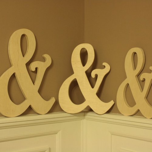 A set of decorative wooden ampersands on a wall.