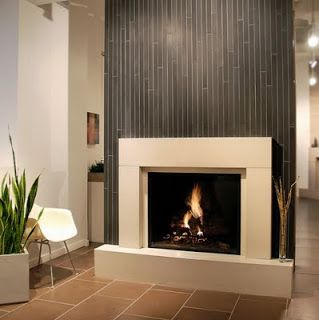 A modern fireplace with a backsplash in a room with tiled walls.