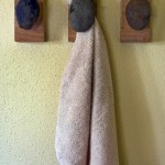 A hand towel hanger with three rocks.