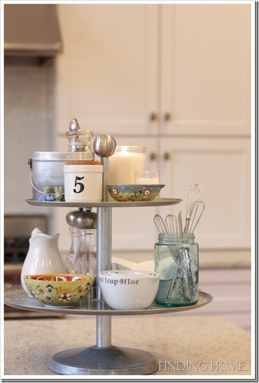 A decluttered kitchen counter with a three-tier tray and bowls.