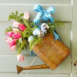 A festive watering can adorned with flowers and tulips, perfect for springtime home decor.