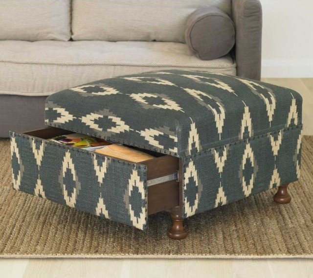 A blue and white ottoman with a drawer under it for pet toy storage.