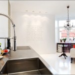 A white kitchen with a sink and a chandelier - Top 15 best looking kitchen faucets.