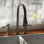A kitchen sink with a stylish faucet.