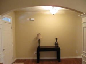 An entryway with hardwood floors and an archway.