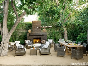 An outdoor patio with wicker furniture and a fireplace.