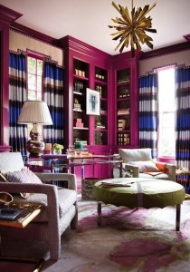 A living room with radiant orchid walls and a chandelier.