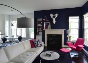 A living room with blue walls and radiant orchid accents.