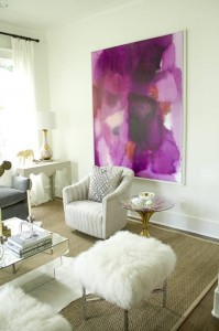 A living room with a radiant orchid painting on the wall.