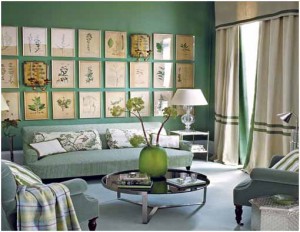 A summer-inspired living room with green walls and framed pictures.