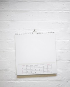 A calendar hanging on a white brick wall, defying bad luck.