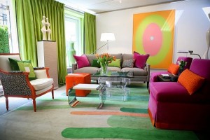 A living room showcasing Fall 2014 design trends with vibrant orange and green accents.