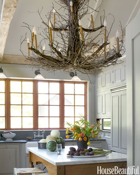 A kitchen with a unique chandelier made of branches.