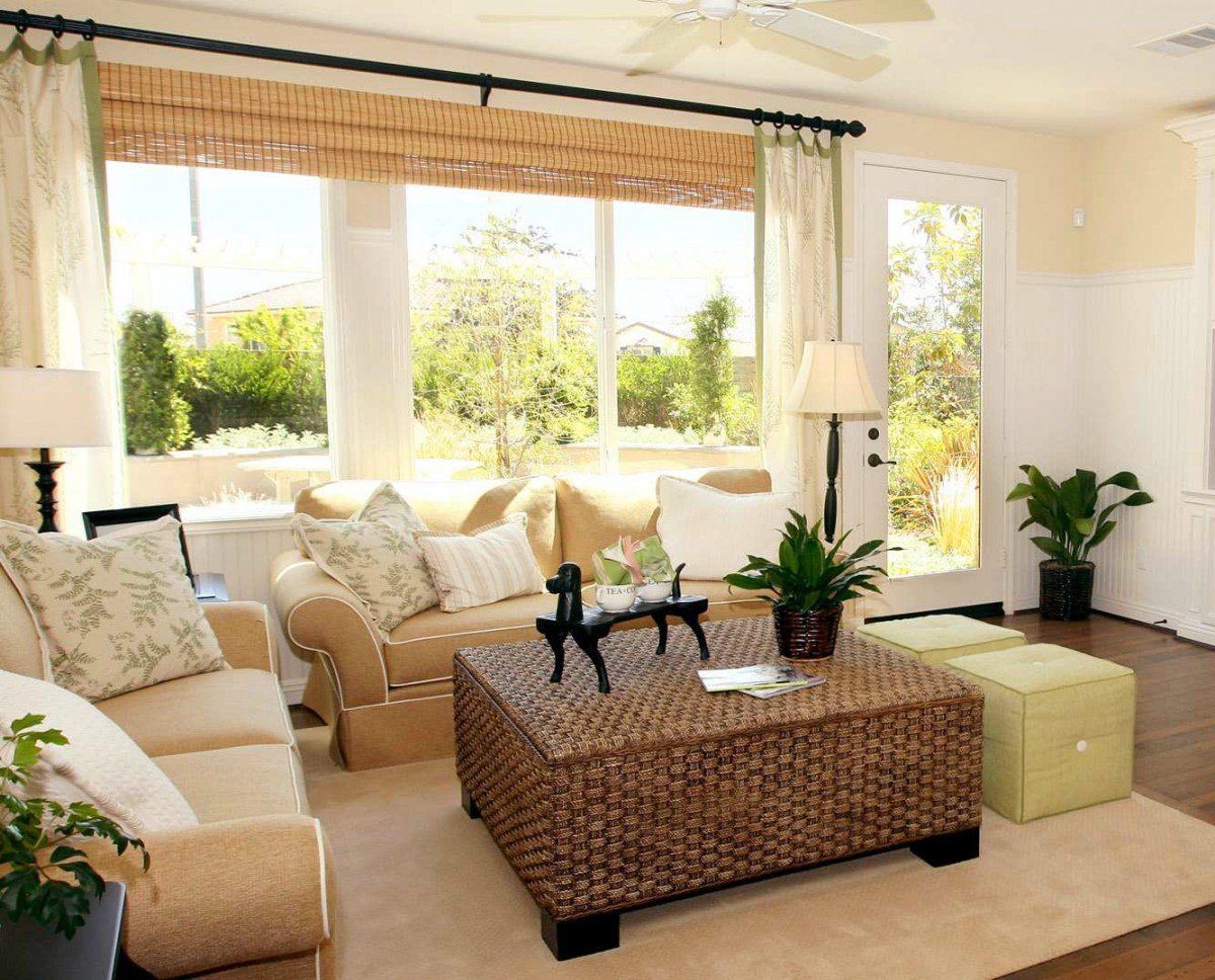 A living room with nature-inspired decorating featuring beige couches and a wicker coffee table.