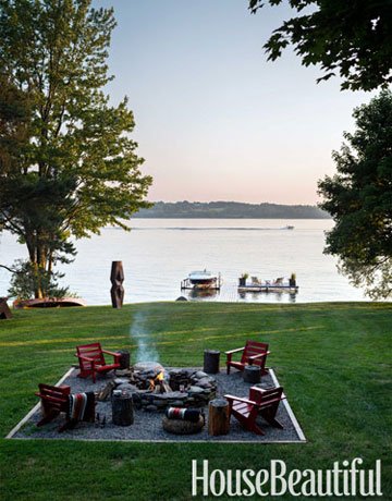 An outdoor fire pit by a lake.