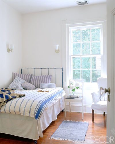A summer bedroom with a blue and white striped bed.