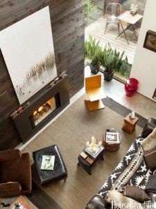 A small living room with a wooden wall and a fireplace.