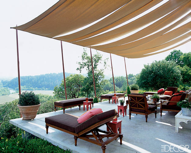 A terrace with furniture and a shady canopy.