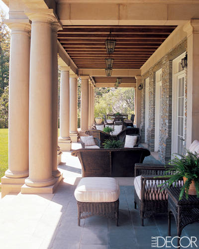 A terrace with wicker furniture and pillars.